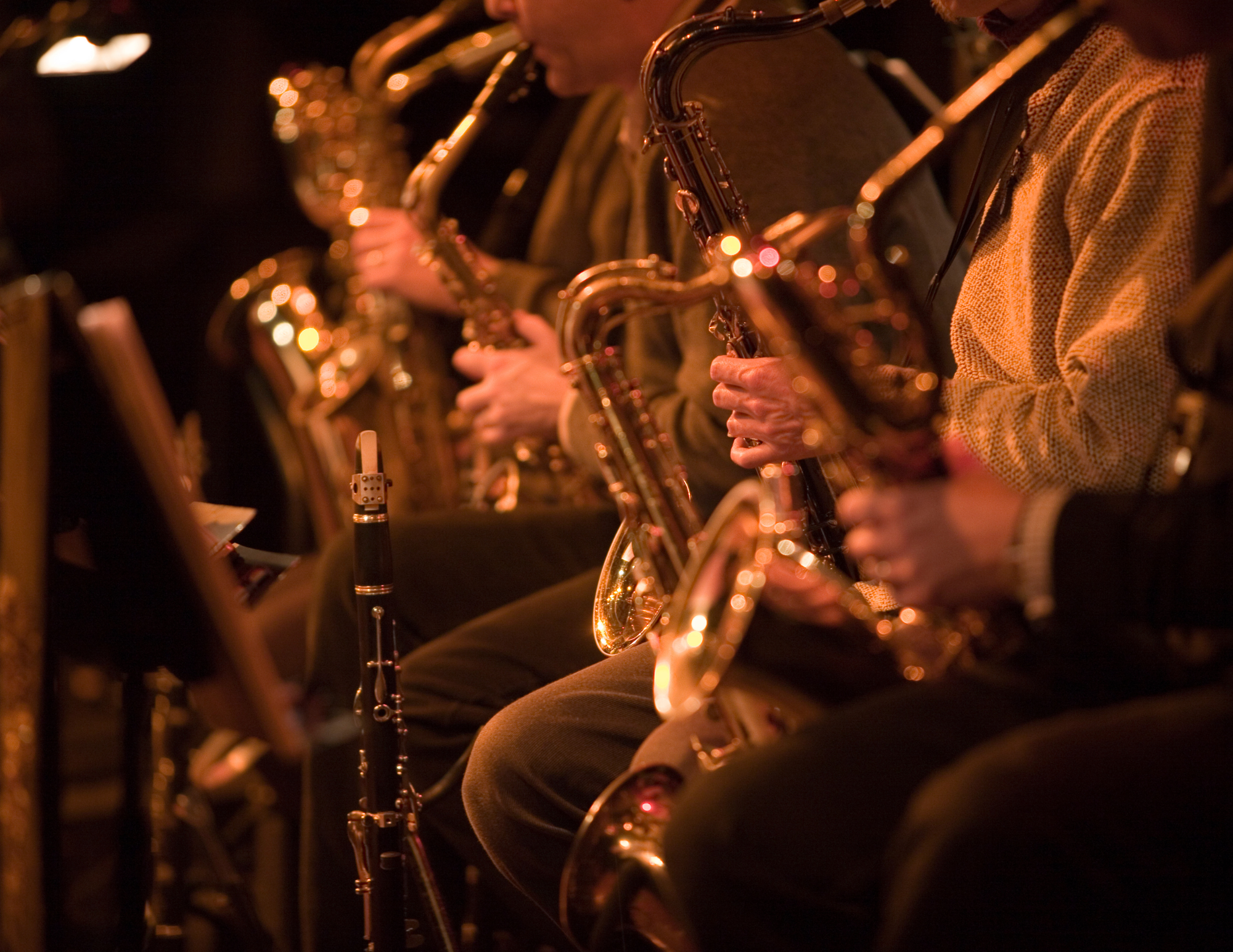Saxophonist silhouetted against warm light, evoking the live jazz at Whiskey Business
